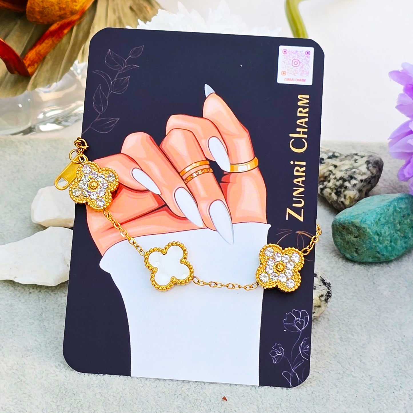 Gold clover bracelet displayed on Zunari Charm branded packaging card.