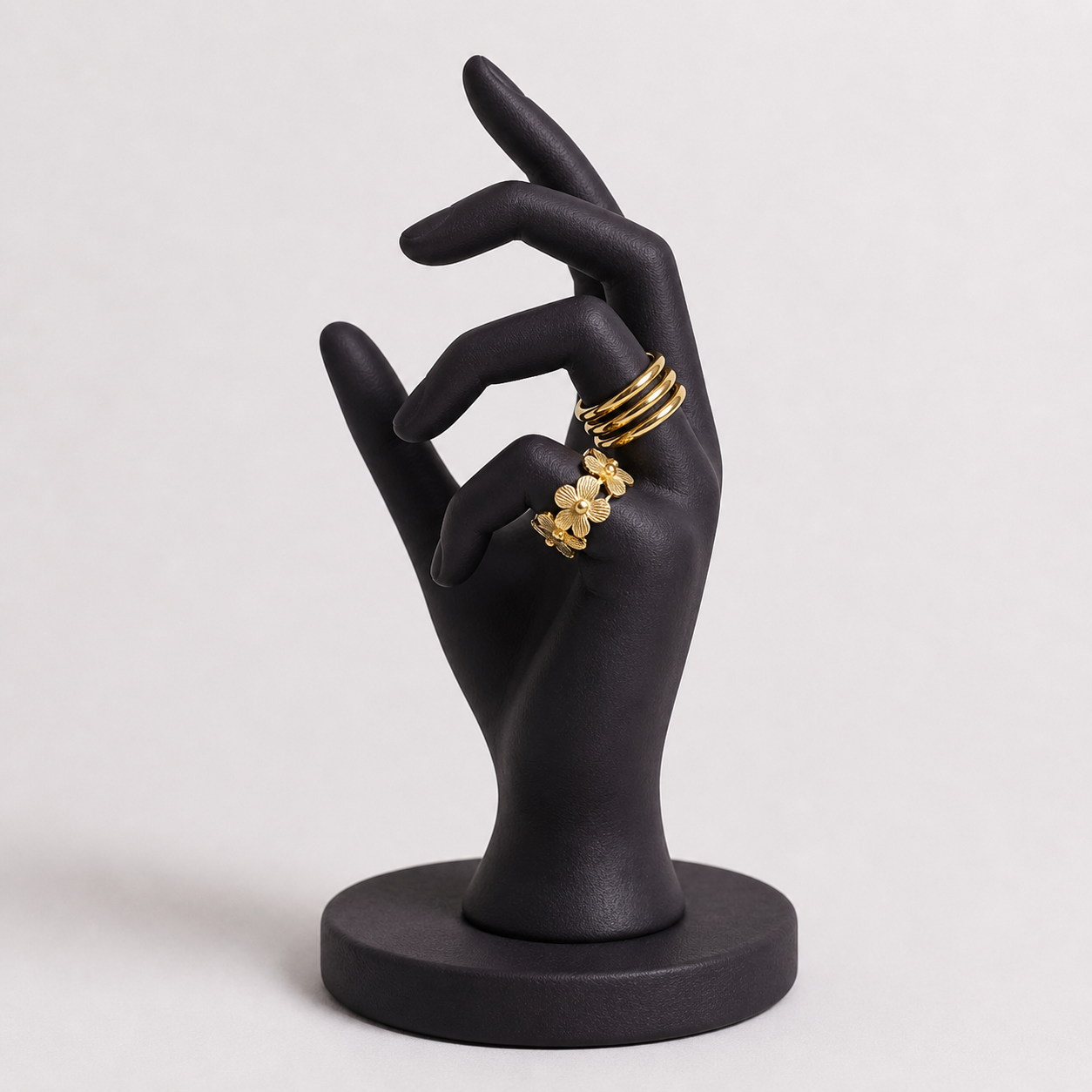 Collection of gold statement rings from Zunari Charm displayed on a grey velvet jewelry tray, featuring designs like butterfly ring, molten drop ring, infinity flow ring, bow knot, and abstract sculptural styles.