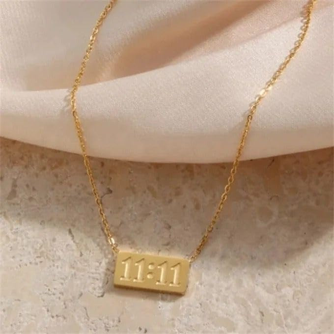 Soft-lit 11:11 necklace placed on a neutral textured surface