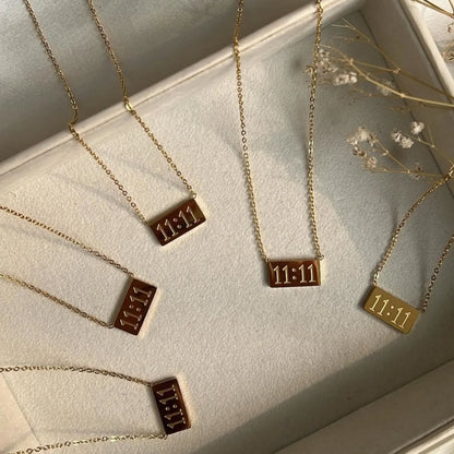 Multiple 11:11 pendant necklaces displayed in a cream jewelry box