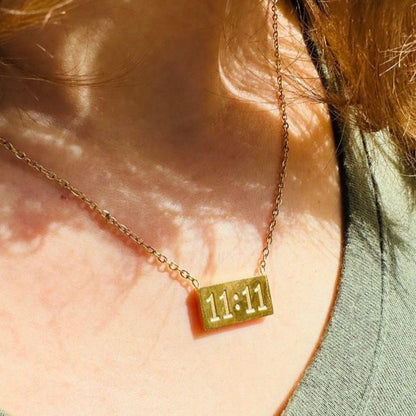 11:11 pendant chain worn close-up, glowing under dappled sunlight