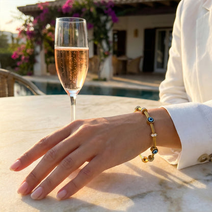Woman wearing gold Amulet cable bangle styled with a white blazer for a luxury resort look.