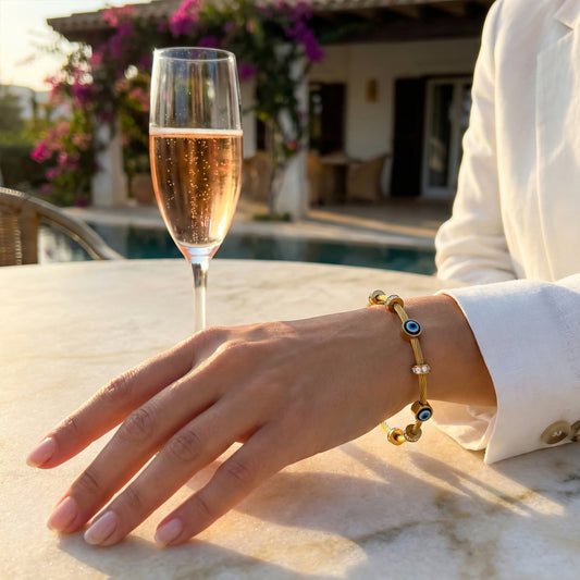Woman wearing gold Amulet cable bangle styled with a white blazer for a luxury resort look.