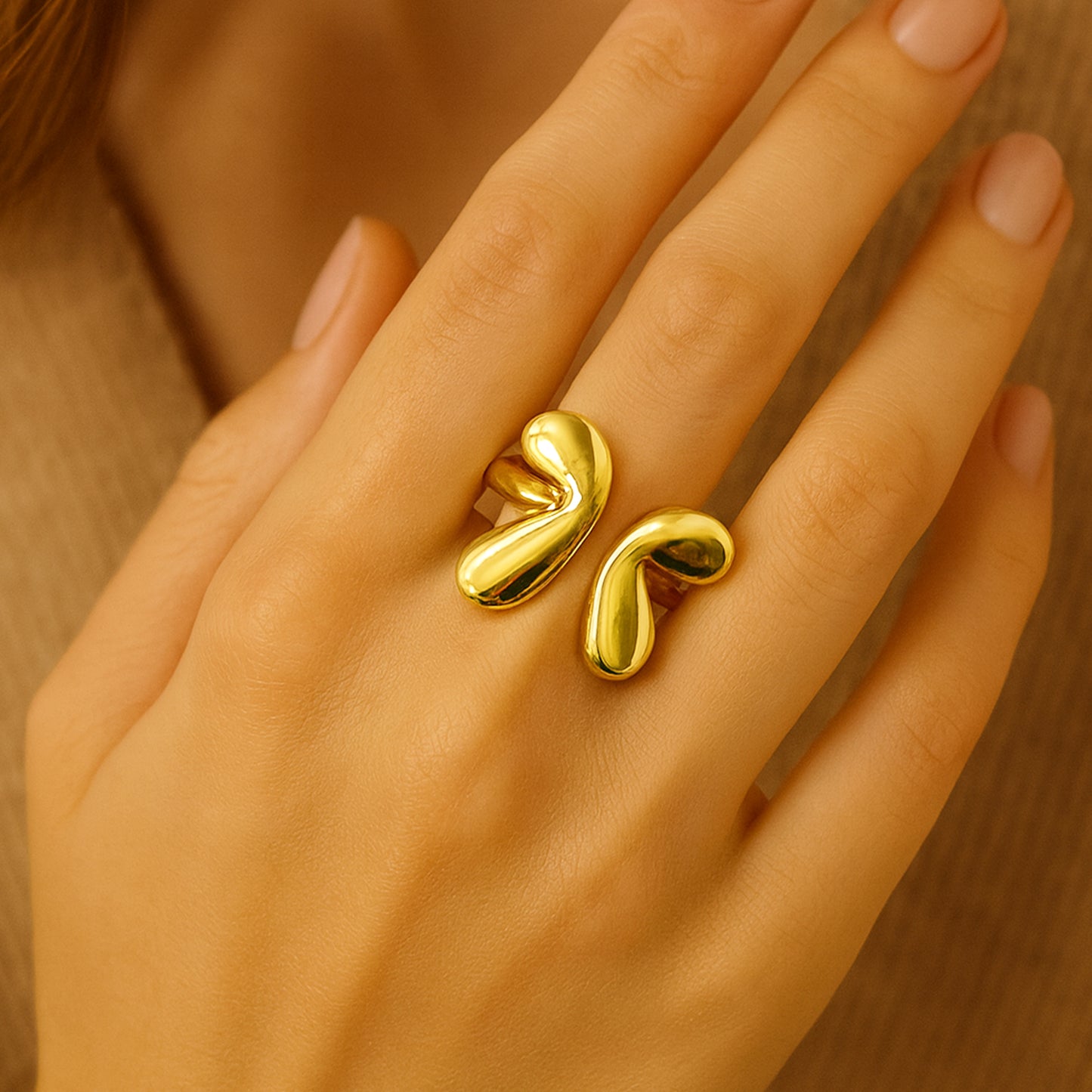 Gold ring on a hand with a neutral background