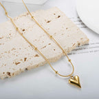 Necklace styled on textured beige stone block with editorial backdrop