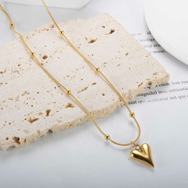 Necklace styled on textured beige stone block with editorial backdrop