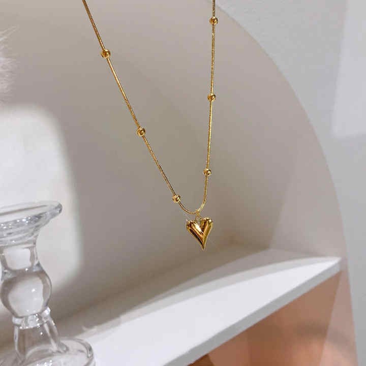 Pendant necklace hanging elegantly from a shelf with glass décor