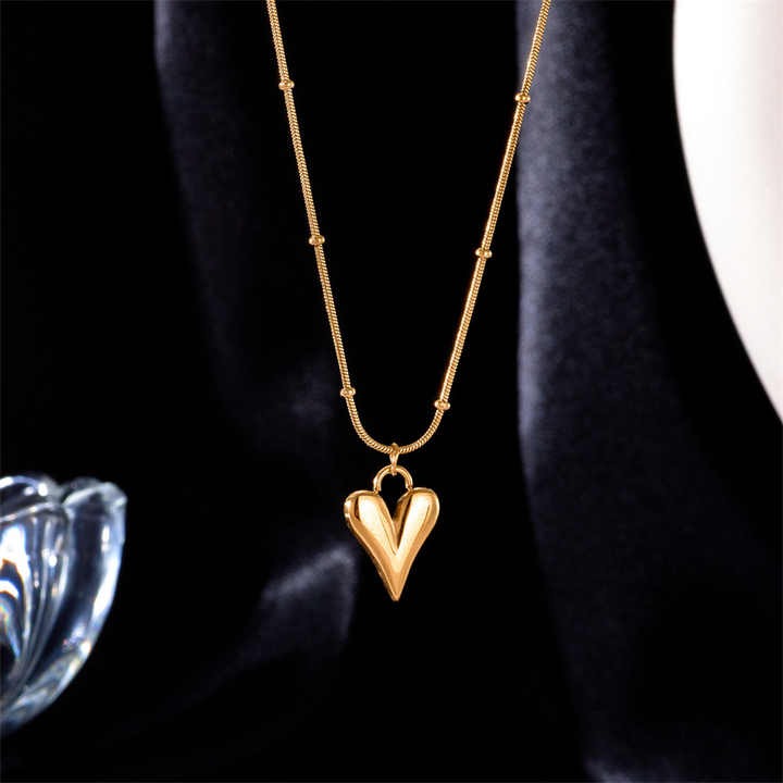 Close-up of teardrop heart pendant hanging against dark background