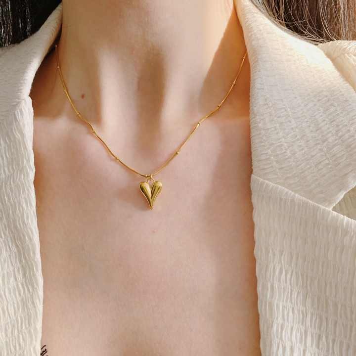 Model wearing water drop heart pendant necklace with open neckline