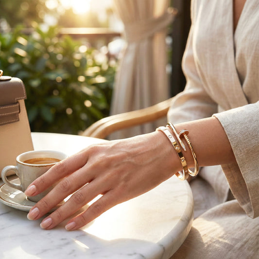 Woman wearing Atelier luxury stack bangles with a coffee cup, showing the nail and screw designs.