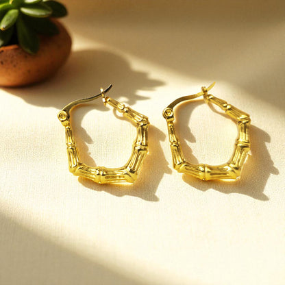 Bamboo Luxe Earrings – gold textured hoops in natural light on beige fabric
