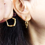 Bamboo Luxe Earrings – close-up of gold bamboo hoops worn on model’s ear