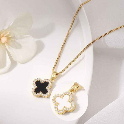 Black and white clover charm pendants shown together