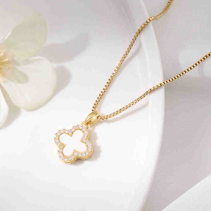 White clover shell enamel necklace flat lay with floral decor