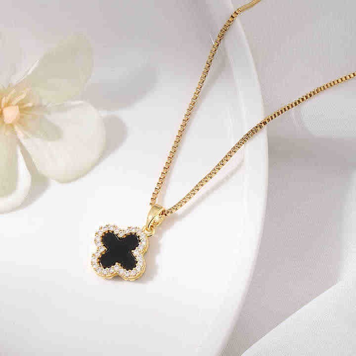 Clover pendant necklace styled on a white dish background