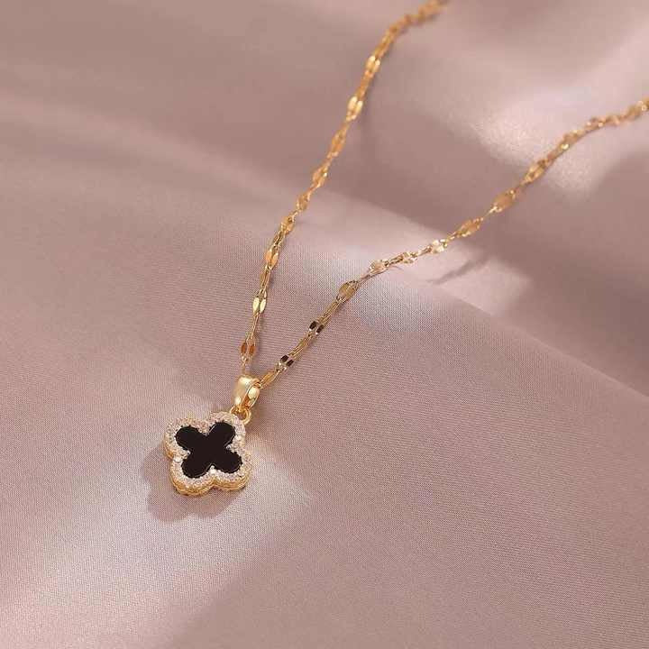 Black clover necklace on satin background, close-up view