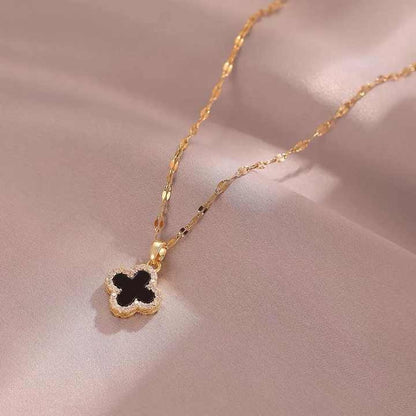 Black clover necklace on satin background, close-up view