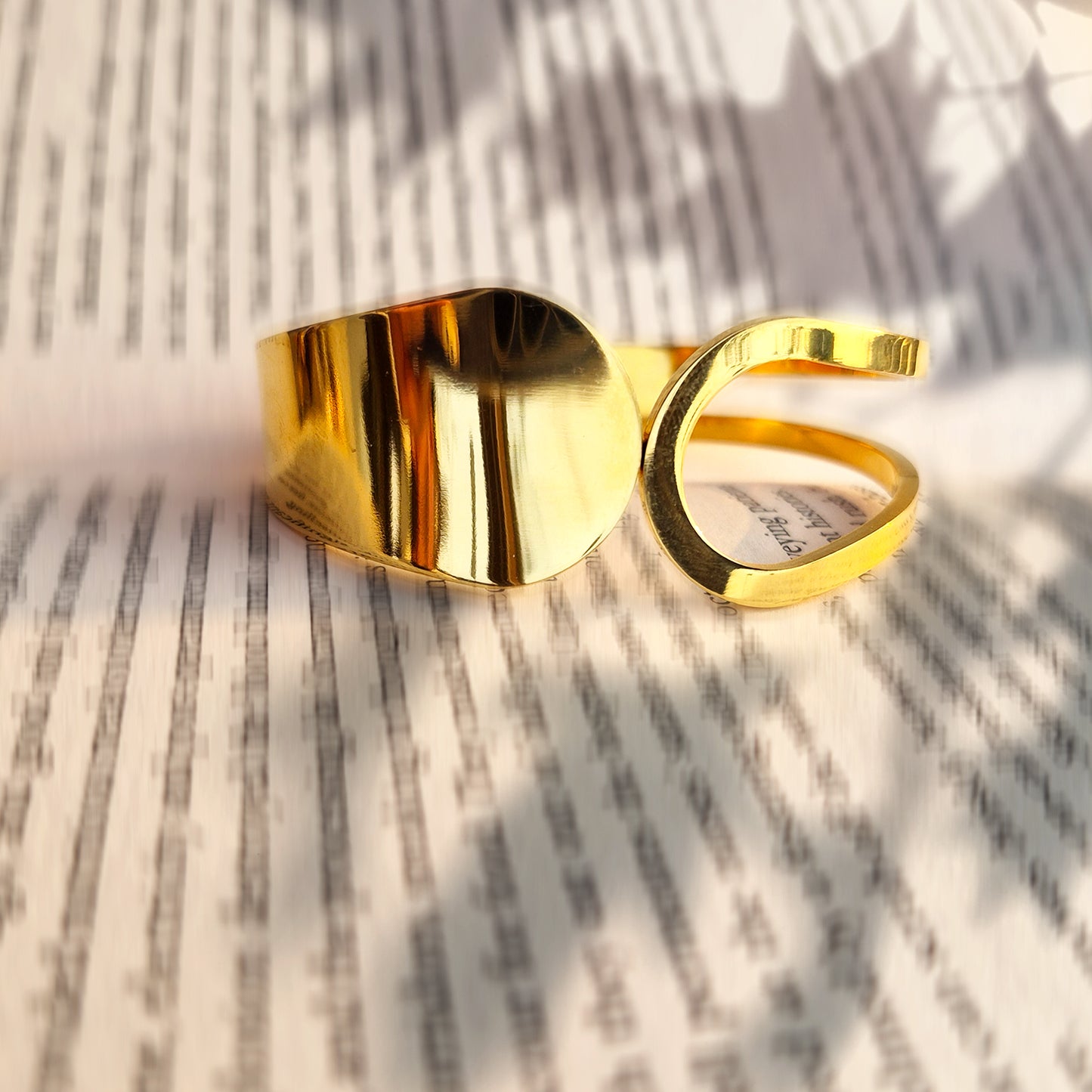 Close-up of high-polish gold statement bangle showing architectural asymmetrical shape.