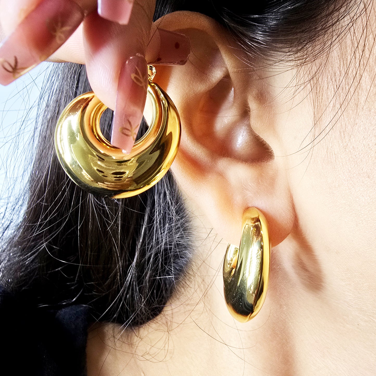 Model wearing Bold Loop Earrings, showcasing bold sculptural hoop design