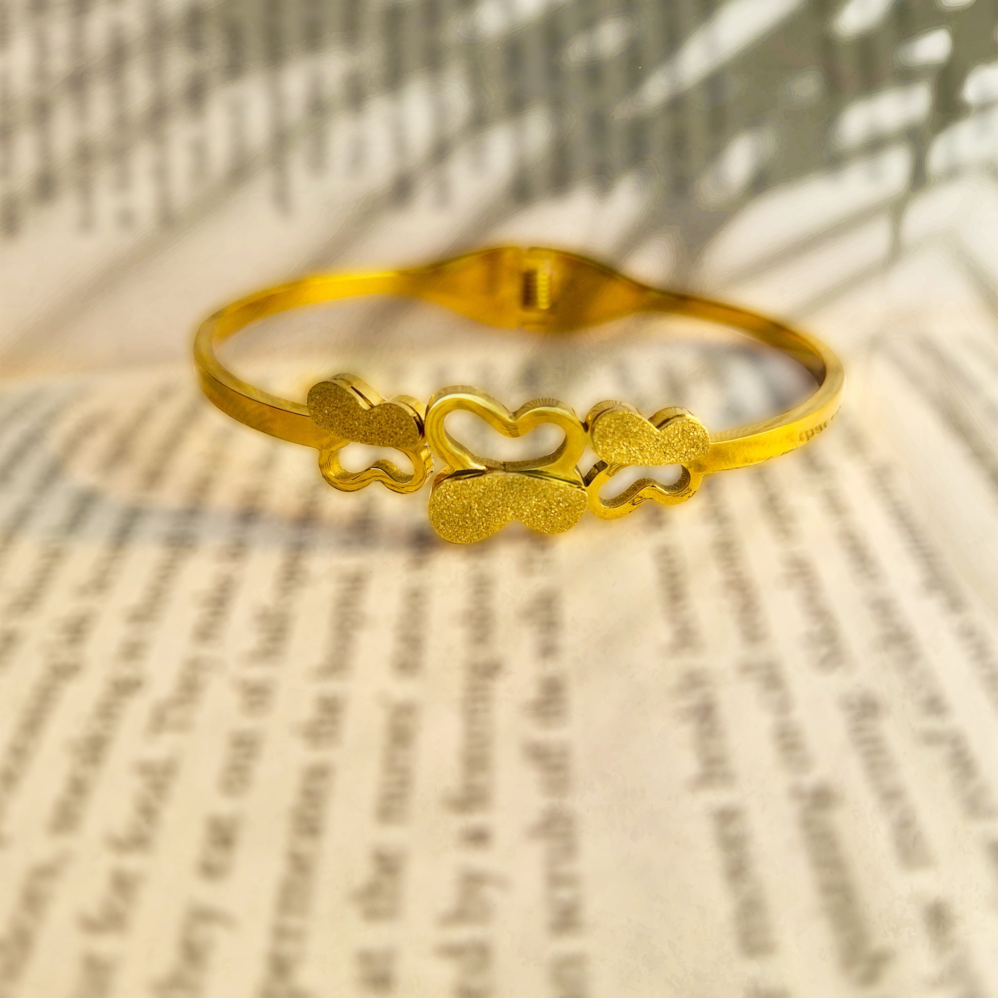 Close-up detail of sandblasted matte gold texture on butterfly wings.