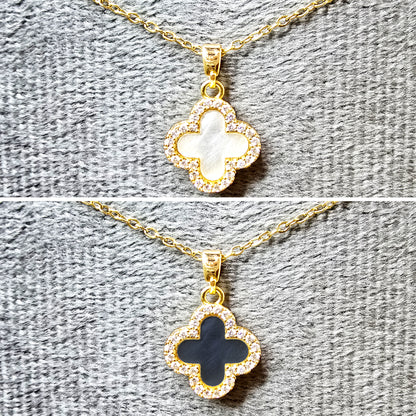 Close-up of the reversible clover pendant showing the solid gold side and the crystal-paved side.