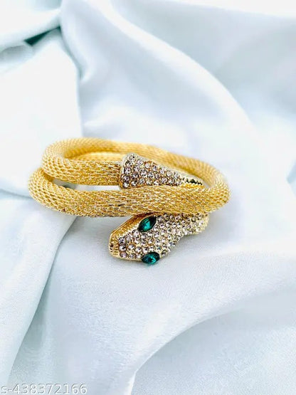 Gold serpent bracelet with crystal-studded snakeheads on white satin background