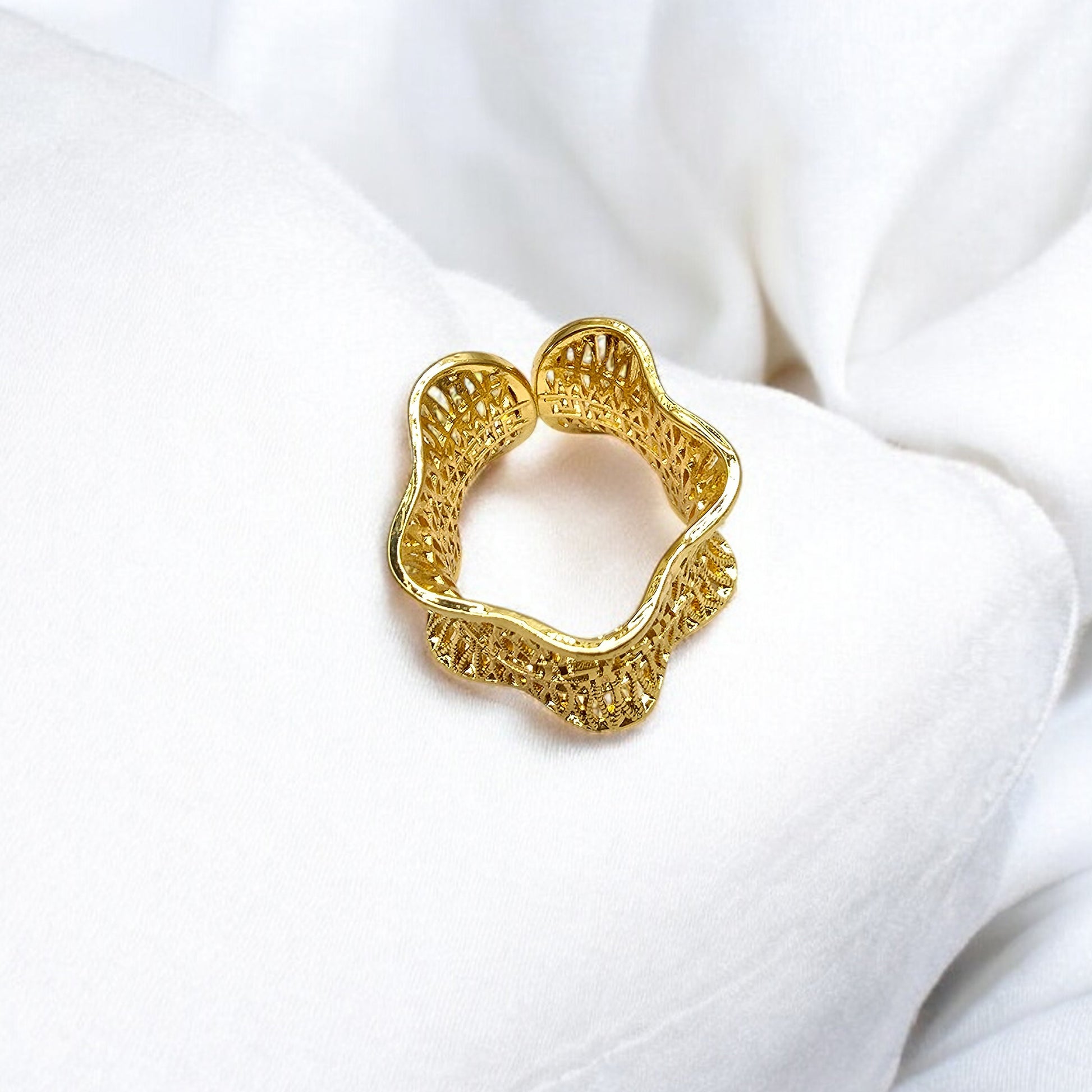 Overhead view of Empress Mesh Ring on soft white fabric, capturing its sculpted mesh-like form.