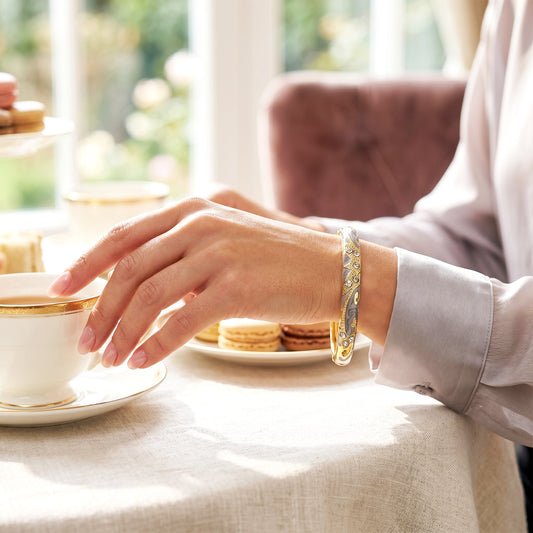 Woman wearing ash crystal bracelet while having tea