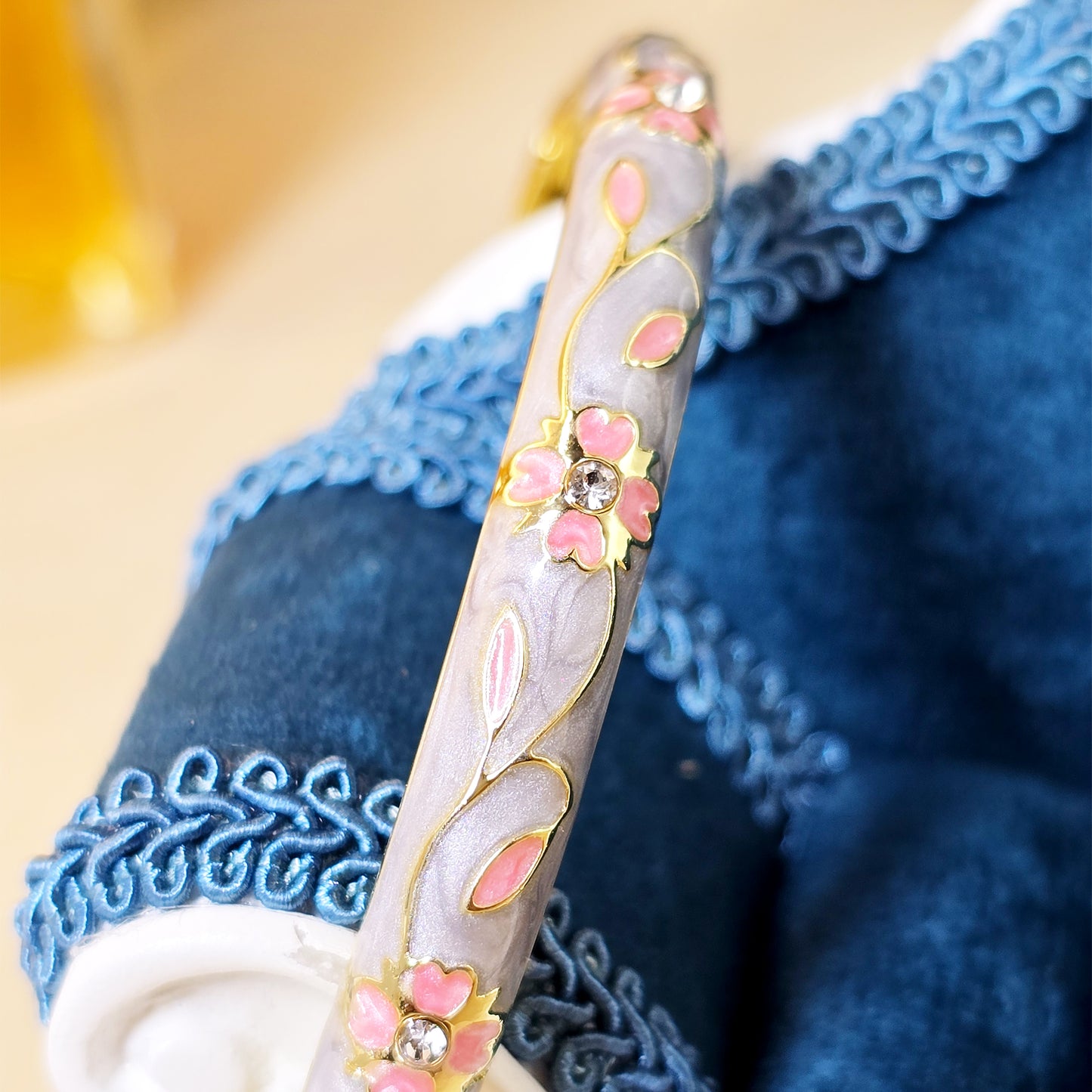Grey enamel bracelet close-up with pink flower crystal detailing