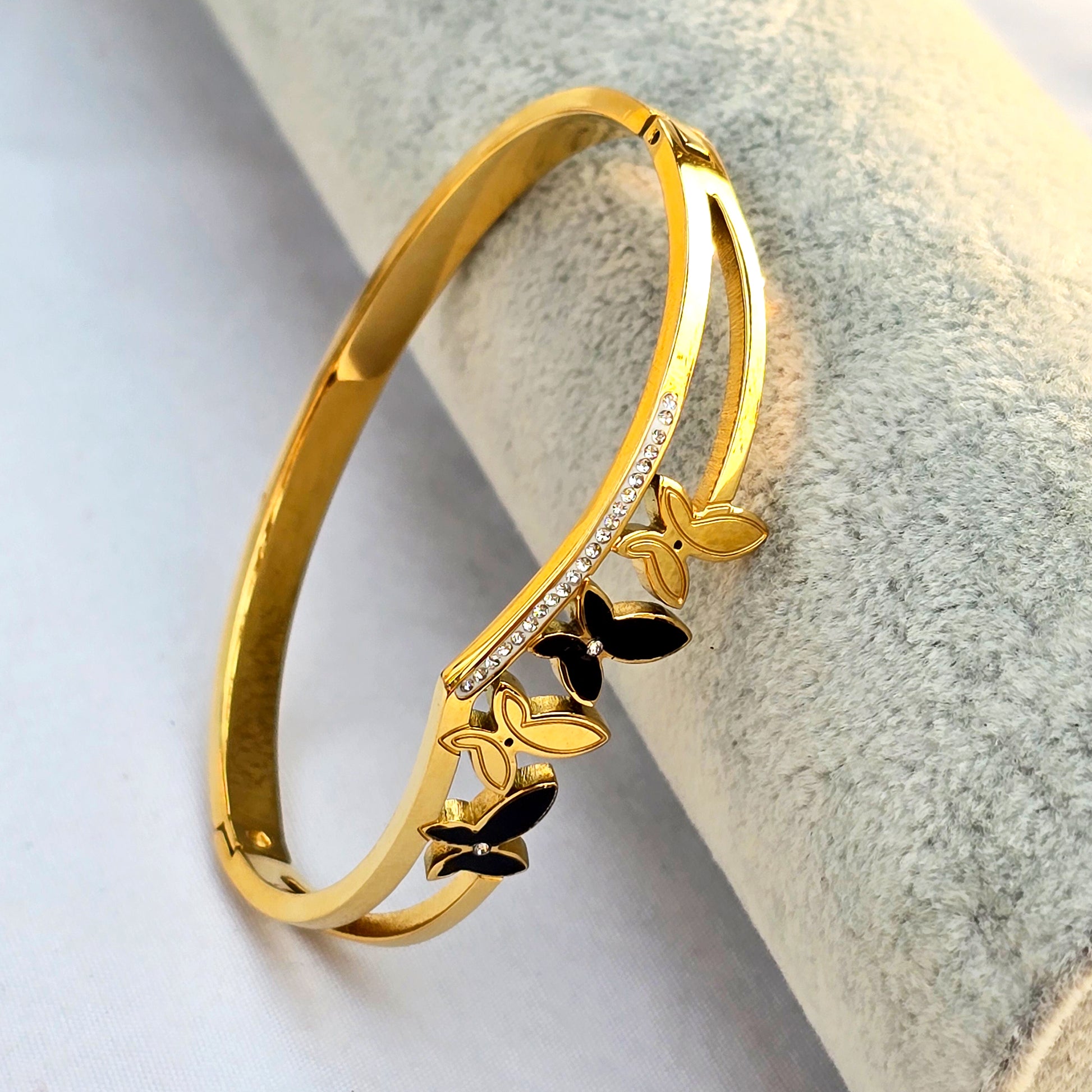 Side view of split-band gold cuff showing chevron shape and butterfly details.