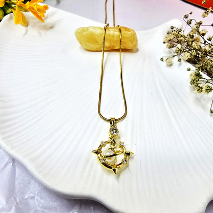Galaxy Charm Pendant Chain displayed on white seashell background – gold pendant with pearl center and spiked orbit design.