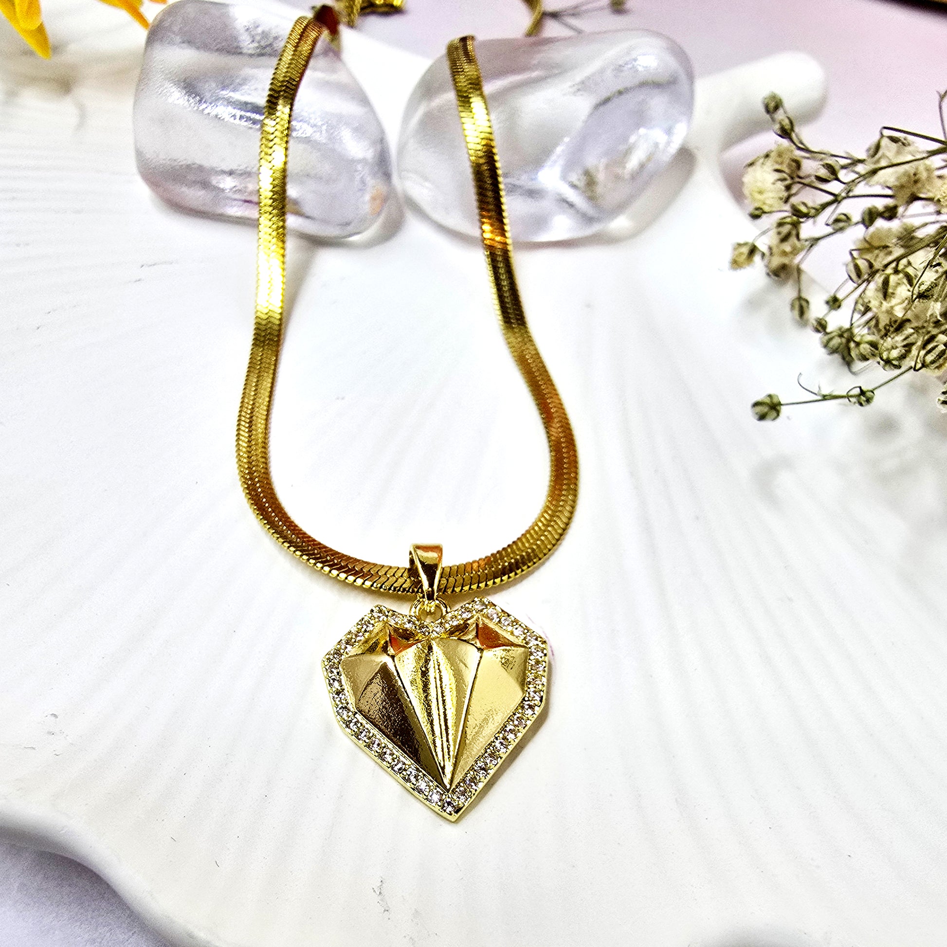 Gold-plated geometric faceted heart pendant necklace on a chunky herringbone chain.