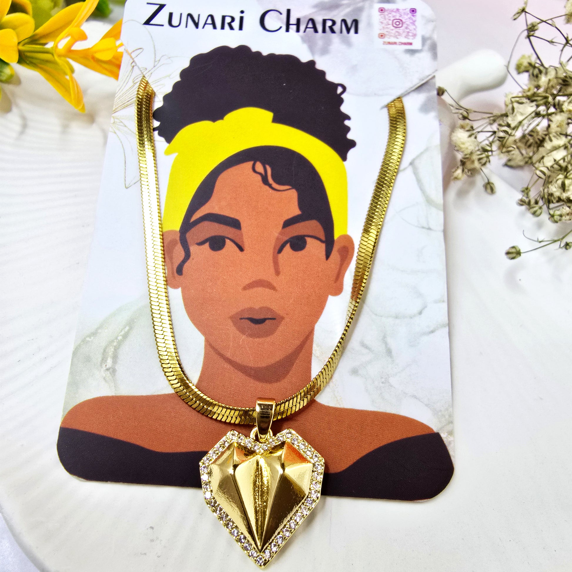 Zunari Charm geometric heart pendant on a wide chain, displayed on a branded jewelry card.