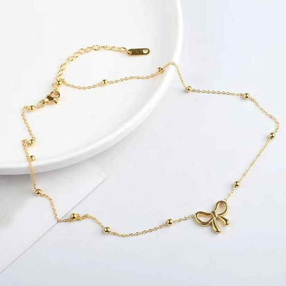 Full view of the Bow & Beads Necklace laid out on a white ceramic plate, displaying the clasp and bead pattern clearly.