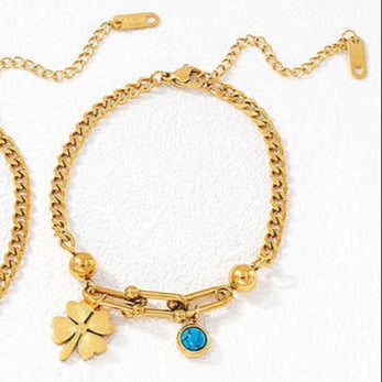 Gold bracelets with charms on a white background