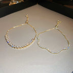 Gold bracelets with embedded stones on a light background
