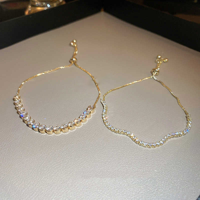 Gold bracelets with embedded stones on a light background