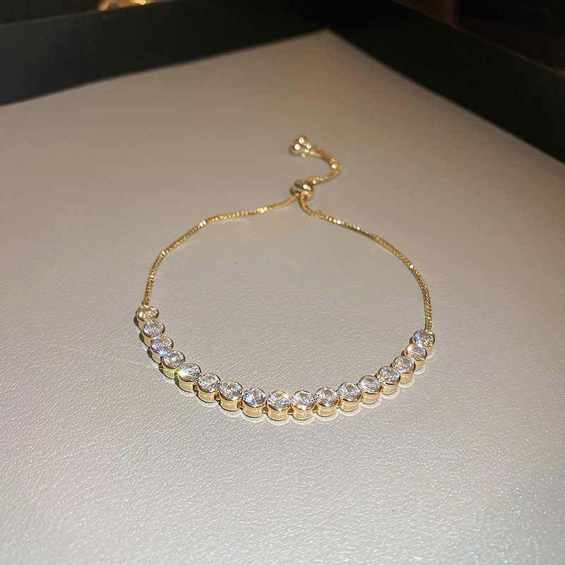 Gold bracelet with clear stones on a light gray surface
