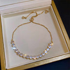 Gold bracelet with crystals on a white cushion in a gold box