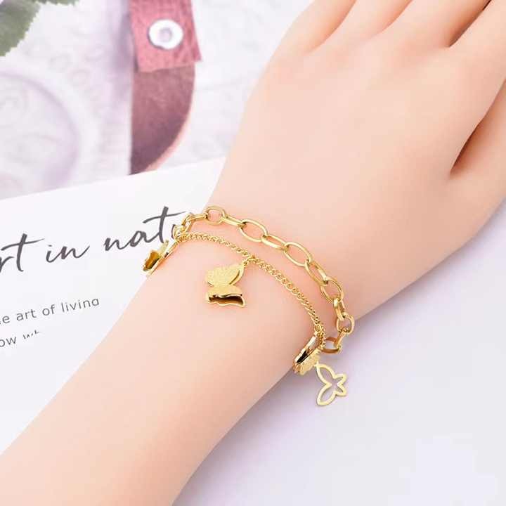 Butterfly charm bracelet worn on a woman’s wrist – close-up