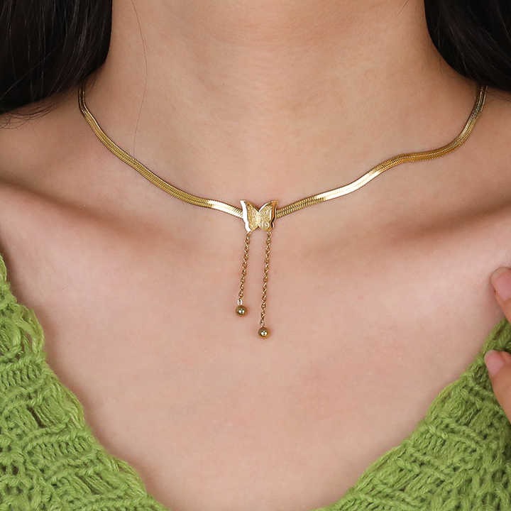 Close-up of butterfly pendant necklace on model