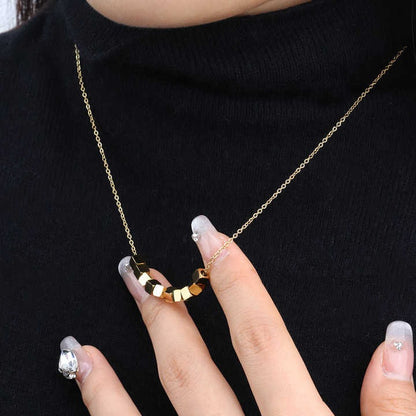 Close-up of Pixel Necklace held by model with designer nails