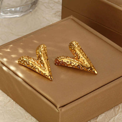 Sculpted gold V earrings displayed elegantly on a Brown jewelry box, highlighting their statement-making shine and texture.