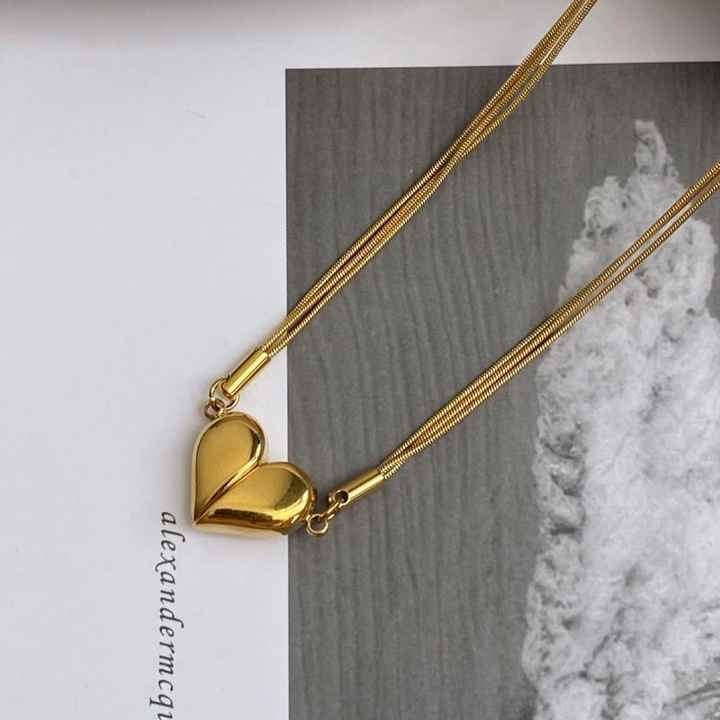 Gold magnetic heart necklace on book flatlay