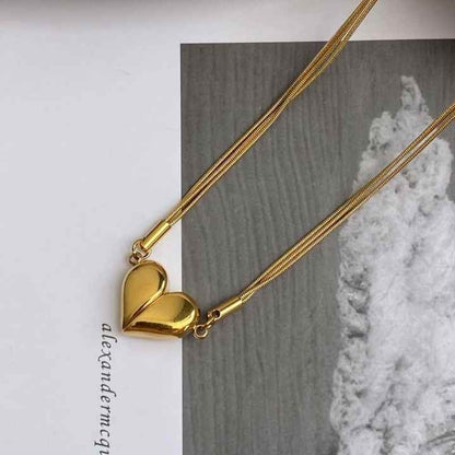 Gold magnetic heart necklace on book flatlay