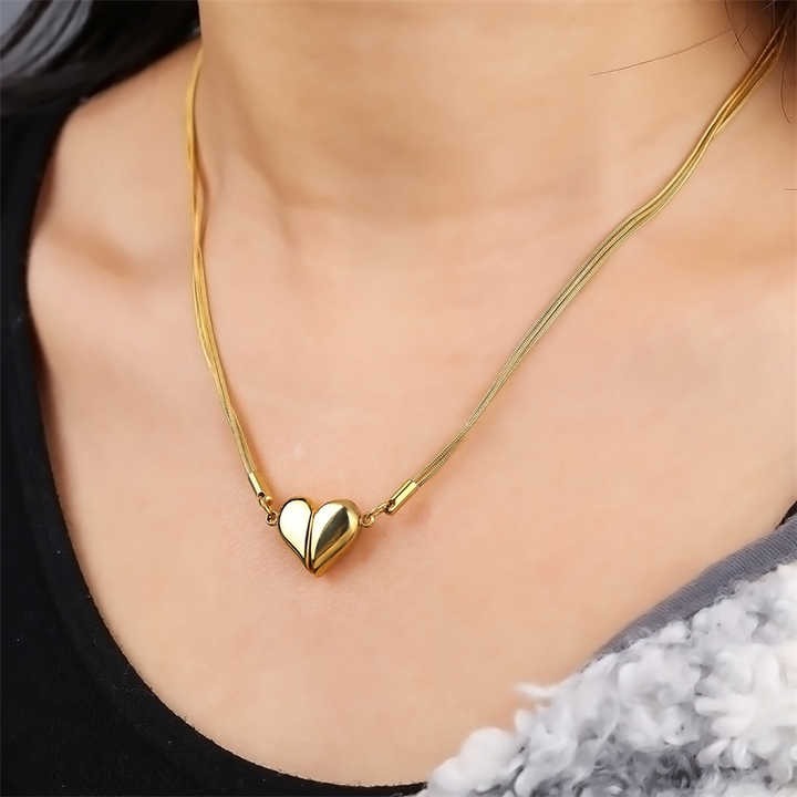 Model wearing glossy gold heart necklace on neckline