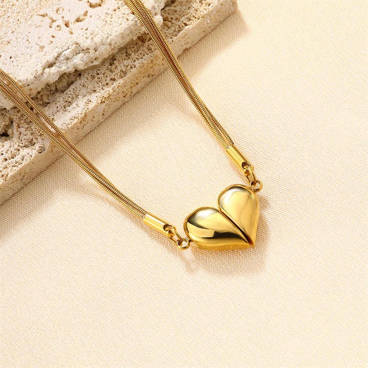 Close-up of gold magnetic heart pendant on soft beige background