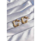 Earrings placed on silky fabric to highlight shine and soft elegance.