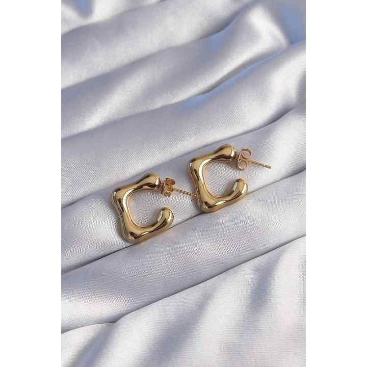 Earrings placed on silky fabric to highlight shine and soft elegance.