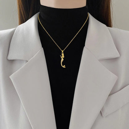 Model styling gold mermaid chain over black top and white blazer